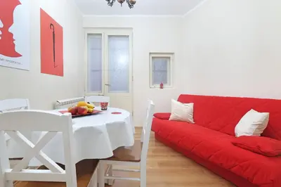 a living room with a red couch and a table at Illusion Downtown Apartment in Belgrade
