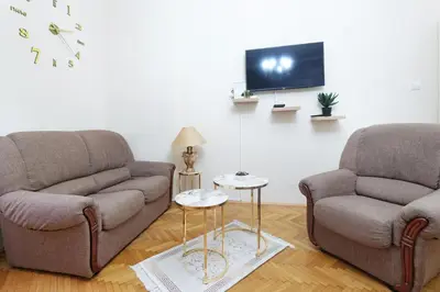 a living room with two couches and a tv at Illusion Downtown Apartment in Belgrade