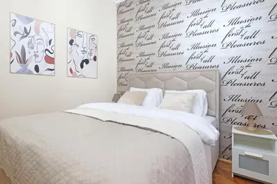 a bedroom with a bed and a wall with writing on it at Illusion Downtown Apartment in Belgrade