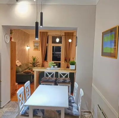 a kitchen and dining room with a white table and chairs at Gracia apartment in Belgrade