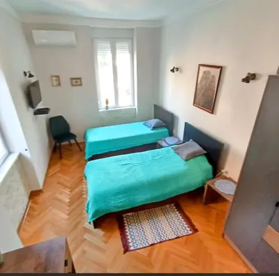 a room with two beds and a window at Gracia apartment in Belgrade