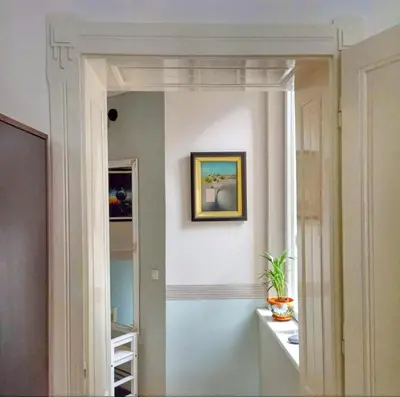 a hallway with a mirror and a painting on a wall at Gracia apartment in Belgrade