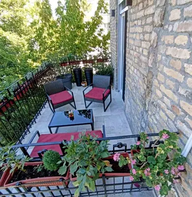 a patio with chairs and tables on a balcony at Gracia apartment in Belgrade