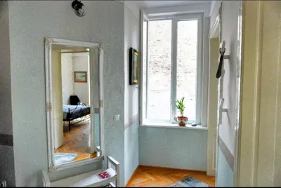 a hallway with a mirror and a window in a room at Gracia apartment in Belgrade