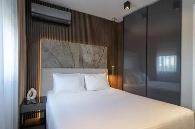 a bedroom with a large white bed with a wall at The Residence 59 in Belgrade