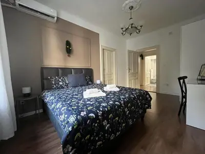 a bedroom with a bed with a blue and white comforter at Old soul of Skadarlija in Belgrade