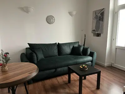 a living room with a green couch and a table at Old soul of Skadarlija in Belgrade