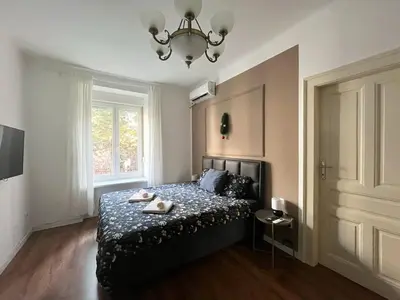 a bedroom with a bed and a chandelier at Old soul of Skadarlija in Belgrade
