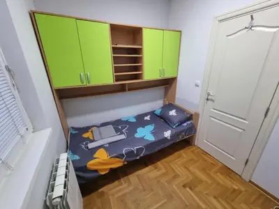 a small room with green cabinets and a bed at Malina in Belgrade