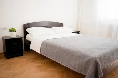 a bedroom with a large bed with white pillows and a table at Downtown, spacious, 2 bedroom apartment in Belgrade