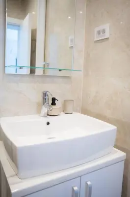 a bathroom with a white sink and a mirror at Downtown, spacious, 2 bedroom apartment in Belgrade
