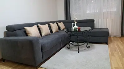 a blue couch with pillows and a table in a living room at Maja 2 in Ruma