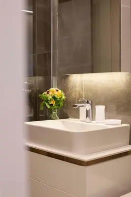 a bathroom with a sink and a vase of flowers at Leo Urban Lux, comfort - Central Stay, Free Garage in Belgrade