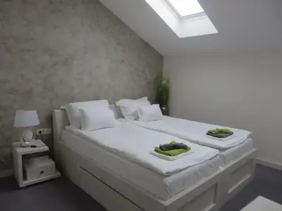 a bedroom with a white bed with two towels on it at Villa Marija M L in Belgrade