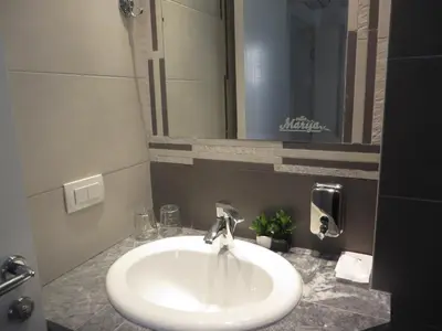a white sink in a bathroom with a mirror at Villa Marija M L in Belgrade