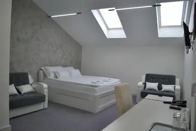 a room with a bed and a couch and windows at Villa Marija M L in Belgrade