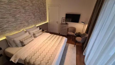 a bedroom with a large bed and a television at Melody Apartment in Novi Beograd
