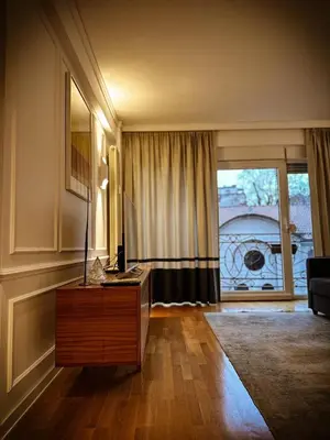 a living room with a table and a large window at Nevski Apartment in Belgrade