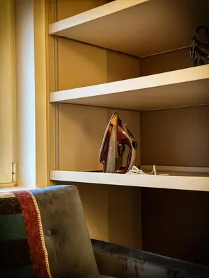 a shelf in a room with a chair on it at Nevski Apartment in Belgrade