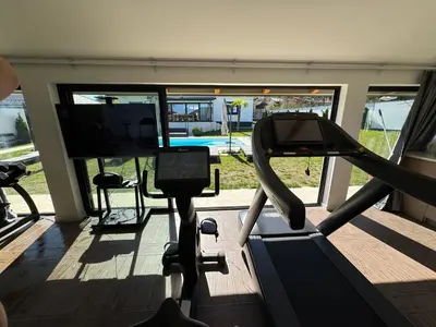 a room with a gym with a tv and a treadmill at The Crown Pool Villa in Belgrade