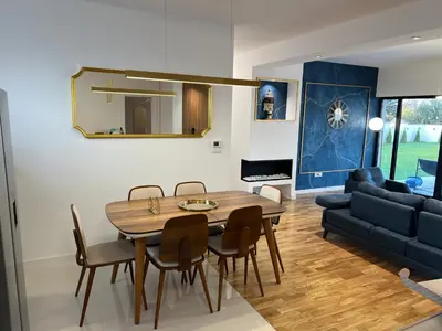 a living room with a table and chairs and a couch at The Crown Pool Villa in Belgrade