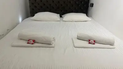 a bed with white towels and red bows on it at The Šljivka in Belgrade