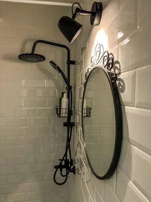 a bathroom with a mirror and lights on a wall at The Šljivka in Belgrade