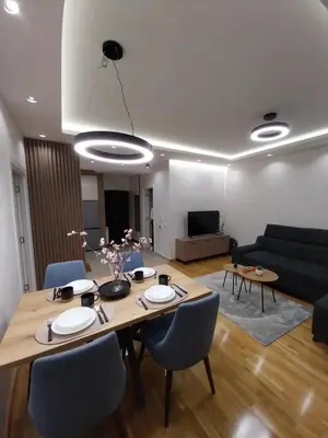 a living room with a table and a couch at Lider Lux Apartman in Arandjelovac