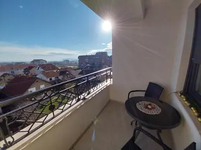 a balcony with a table and a view of a city at Lider Lux Apartman in Arandjelovac