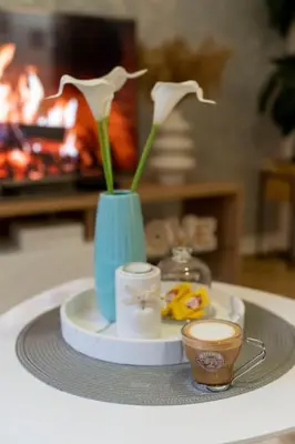 a tray with a blue vase with flowers and two cups at Train 23 in Belgrade