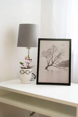 a table with a picture and a lamp and a vase with flowers at Train 23 in Belgrade