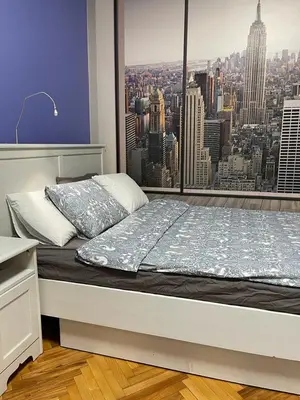 a bed in a room with a view of a city at Palma studio in Belgrade