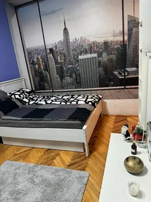 a bed in a room with a view of a city at Palma studio in Belgrade