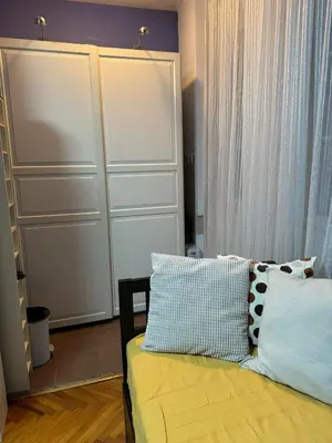a bedroom with a yellow bed with two pillows at Palma studio in Belgrade
