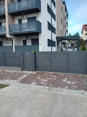 a fence in front of a building with a balcony at Ruma Deluxe 90m2 in Ruma