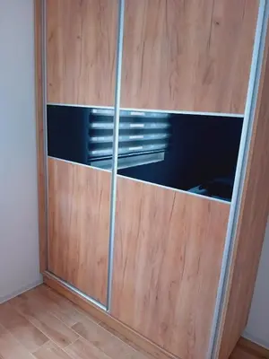 a wooden closet with glass doors in a room at Ruma Deluxe 90m2 in Ruma