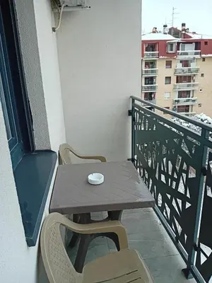 a wooden table and chairs on a balcony at Ruma Deluxe 90m2 in Ruma