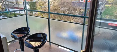 two chairs sitting on a balcony looking out of a window at Grey apartment Novi Beograd in Belgrade
