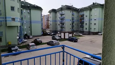 a group of apartment buildings with cars parked in a parking lot at Apartman Anja in Velika Granice