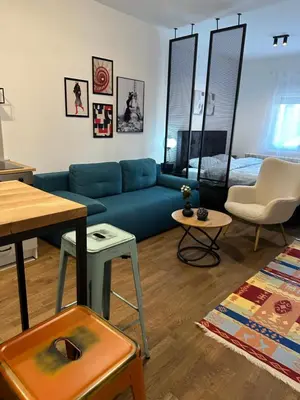 a living room with a blue couch and a bed at Sleep&Fly Belgrade in Ledine