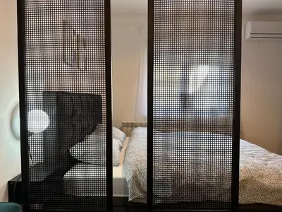 a screened in room with a bed and a chair at Sleep&Fly Belgrade in Ledine