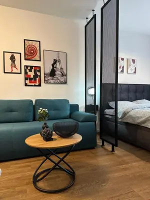 a living room with a blue couch and a table at Sleep&Fly Belgrade in Ledine