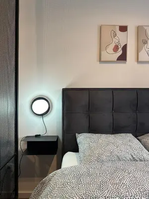 a bedroom with a bed with a black headboard and a lamp at Sleep&Fly Belgrade in Ledine