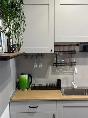 a kitchen with white cabinets and a sink and a green appliance at Sleep&Fly Belgrade in Ledine