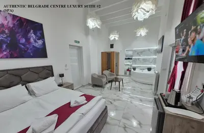 a bedroom with a bed and a bathroom with a tub at Authentic Belgrade Centre Suites with Patios in Courtyard for Smokers in Belgrade