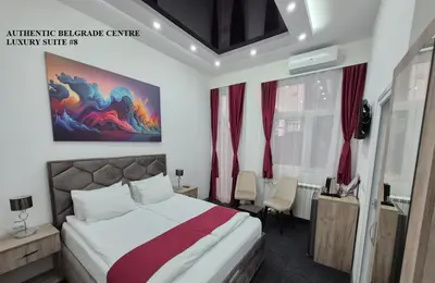 a hotel room with a bed and a desk at Authentic Belgrade Centre Suites with Patios in Courtyard for Smokers in Belgrade