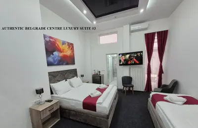 a hotel room with two beds and a tv at Authentic Belgrade Centre Suites with Patios in Courtyard for Smokers in Belgrade