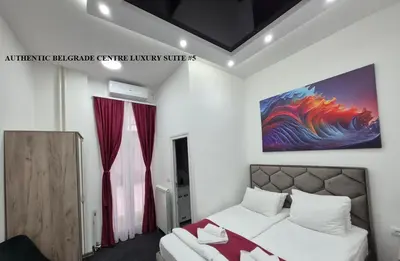 a bedroom with a bed and a painting on the wall at Authentic Belgrade Centre Suites with Patios in Courtyard for Smokers in Belgrade