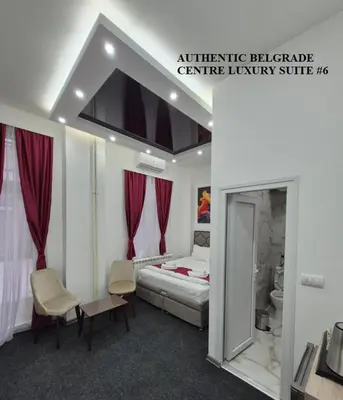 a hotel room with a bed and a bathroom at Authentic Belgrade Centre Suites with Patios in Courtyard for Smokers in Belgrade