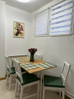 a dining room table with chairs and a vase of flowers at NBG113 apartment in Belgrade